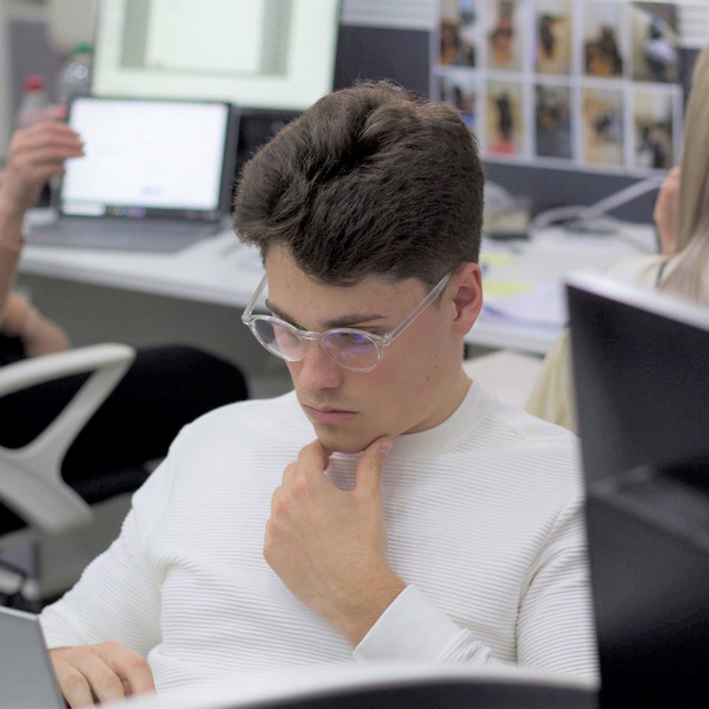 white male with eyeglasses looking at the laptop